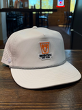 White cap with a logo on a wooden table in a casual setting