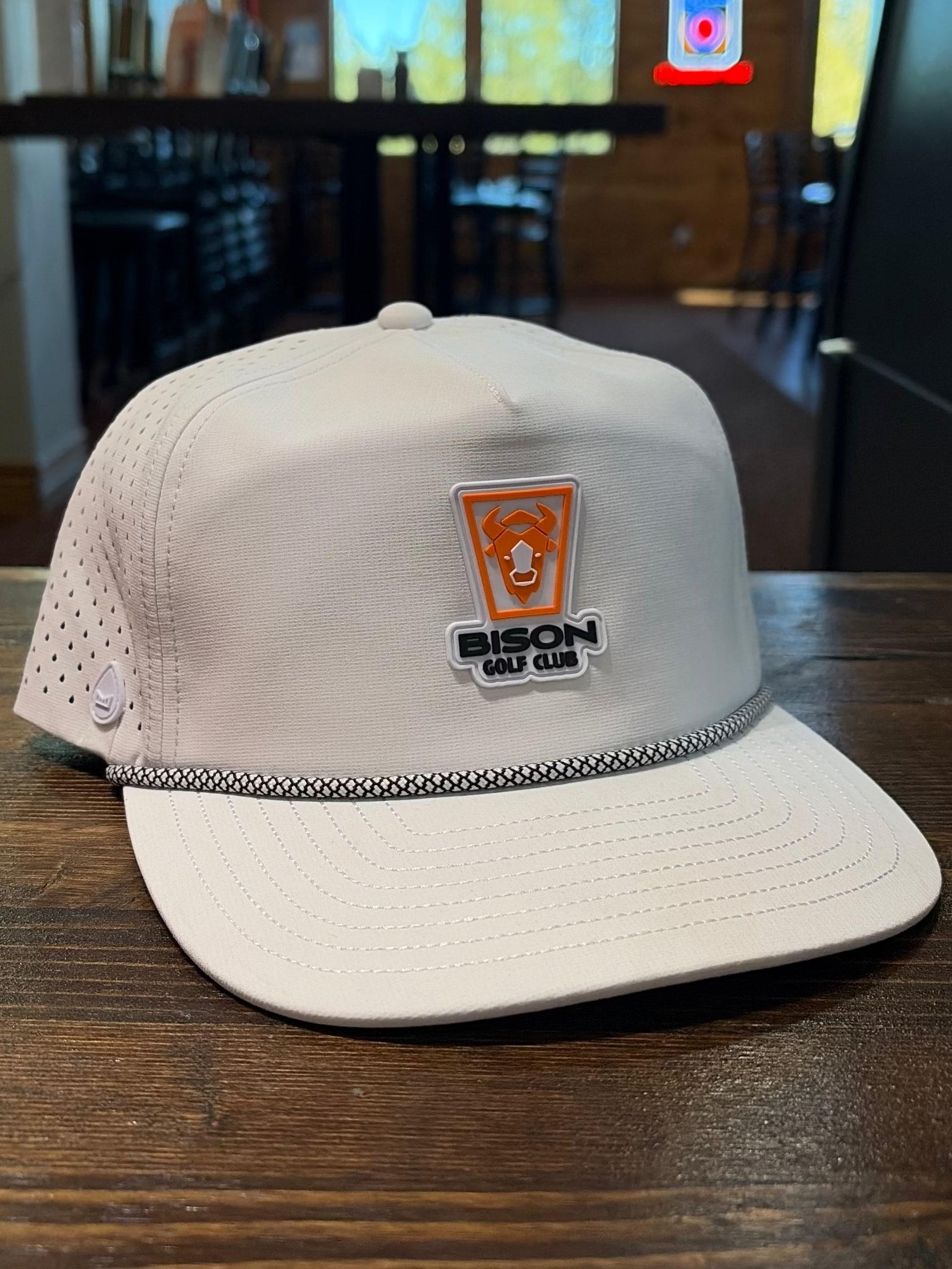 White cap with a logo on a wooden table in a casual setting