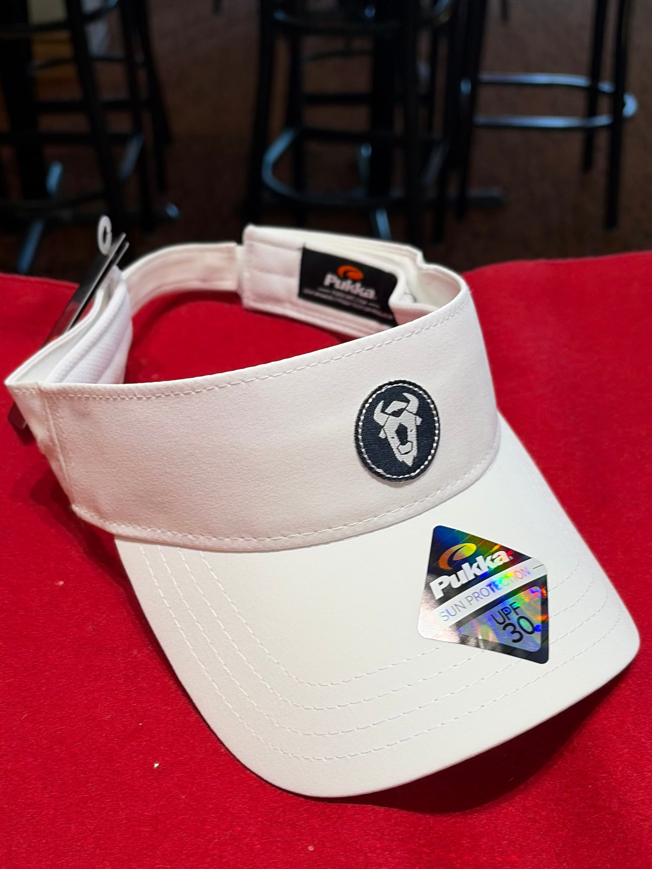 White visor with branding on a red surface